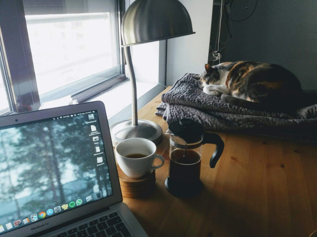 Portátil y taza de café en una mesa, terapia psicológica online por videollamada